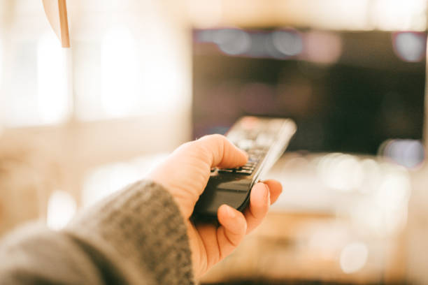 hand using remote tv  control at home